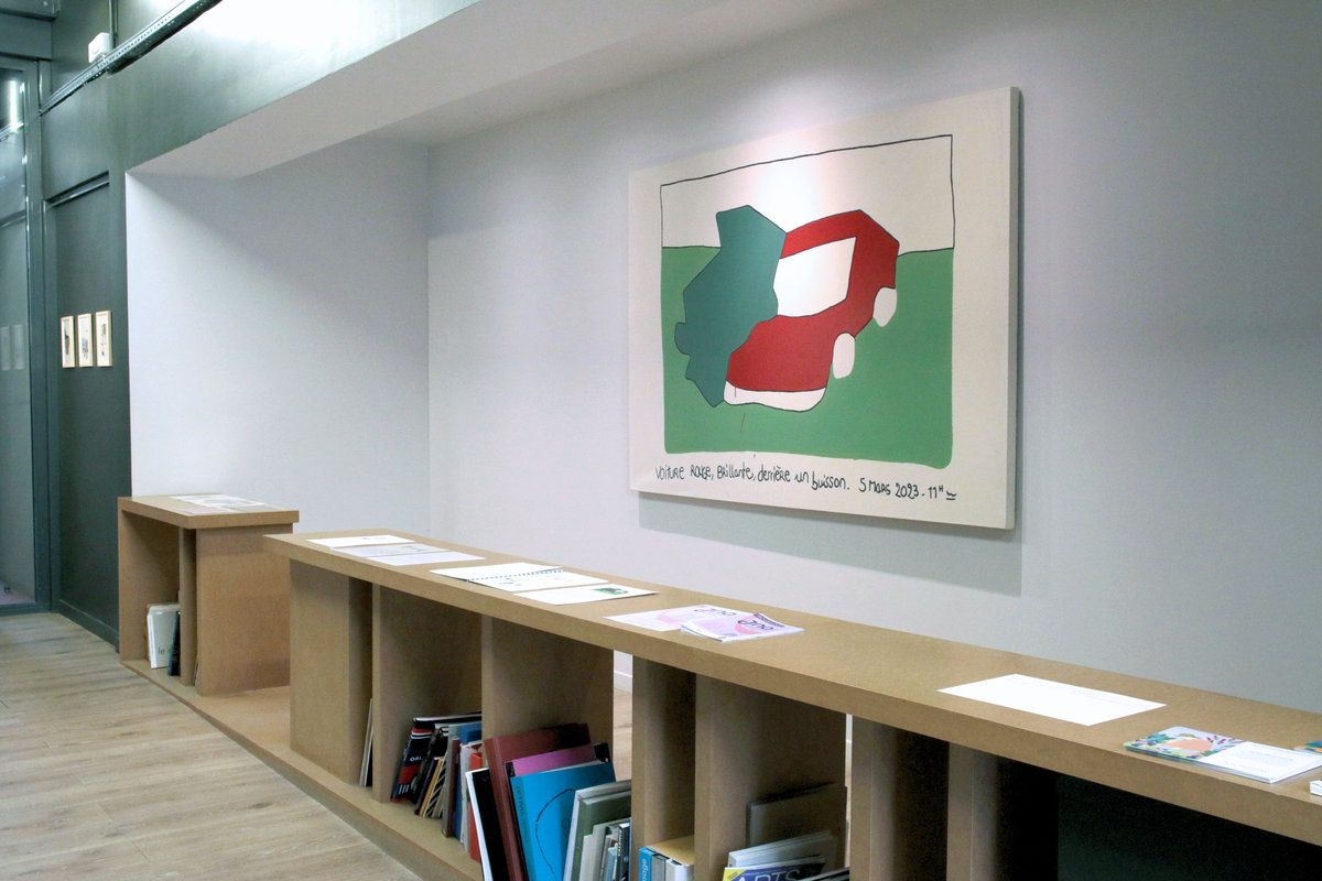 Voiture rouge brillante derrière un buisson